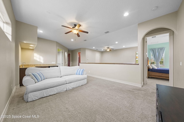 living room featuring ceiling fan and light colored carpet