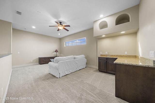 bedroom featuring connected bathroom, ceiling fan, and light colored carpet