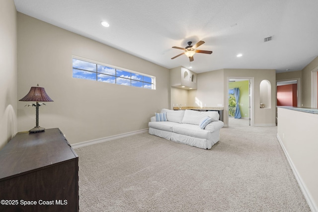 carpeted living room with ceiling fan