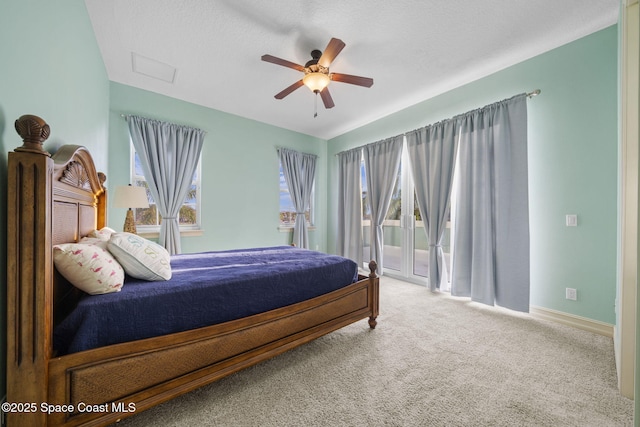 bedroom with ceiling fan, access to exterior, carpet floors, and a textured ceiling