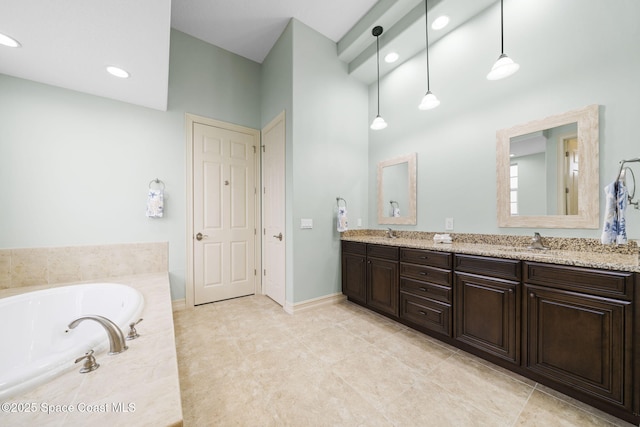 bathroom featuring vanity and tiled bath