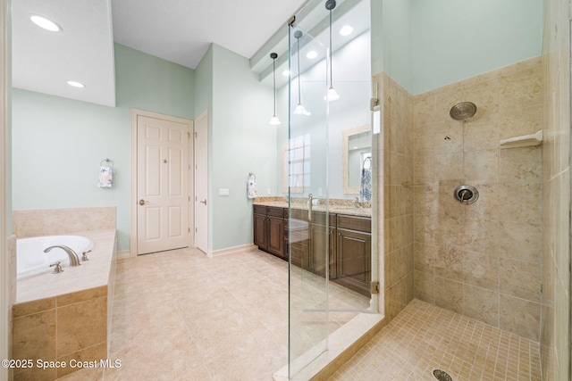 bathroom featuring plus walk in shower, vanity, and tile patterned flooring