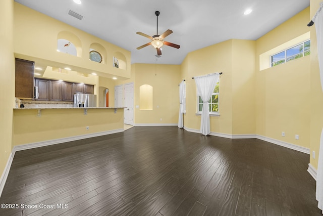 unfurnished living room with ceiling fan and dark wood-type flooring