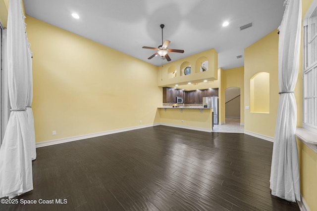 unfurnished living room featuring ceiling fan and dark wood-type flooring