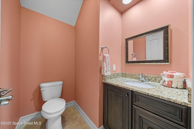 bathroom with vanity, a textured ceiling, tile patterned flooring, toilet, and lofted ceiling