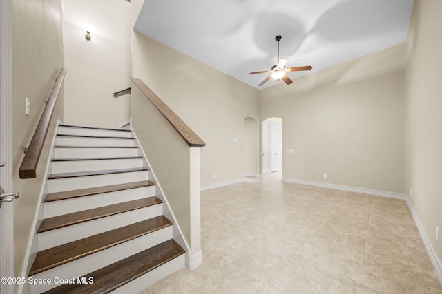 staircase featuring ceiling fan