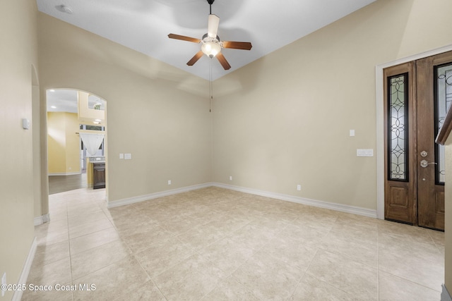 tiled spare room featuring ceiling fan