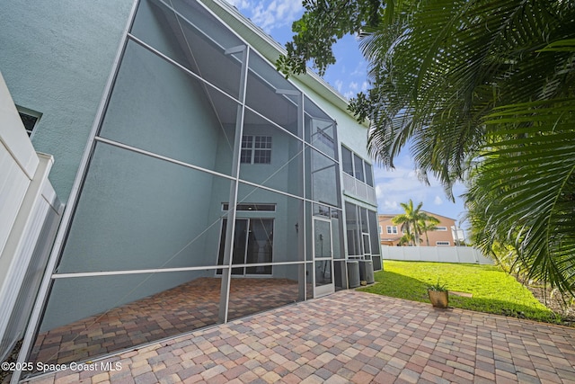 rear view of property featuring a lawn and a patio area