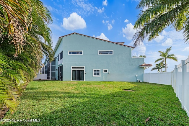 rear view of property featuring a lawn