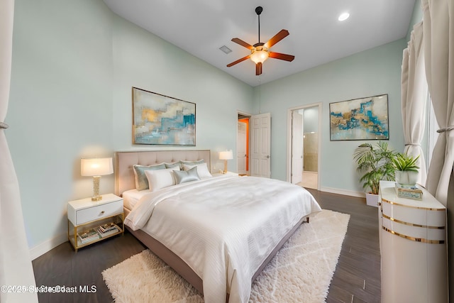 bedroom featuring connected bathroom, ceiling fan, and dark hardwood / wood-style flooring