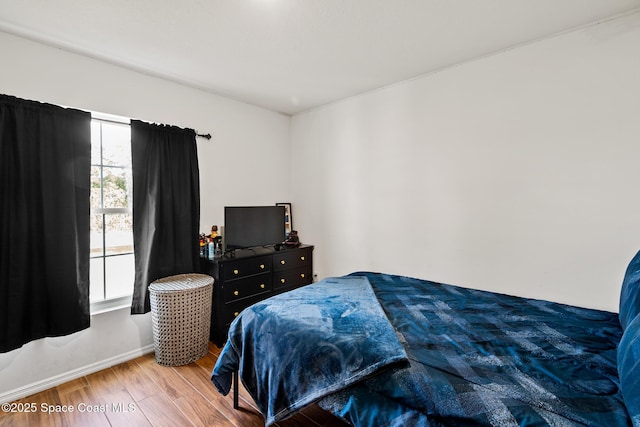 bedroom with hardwood / wood-style flooring and multiple windows