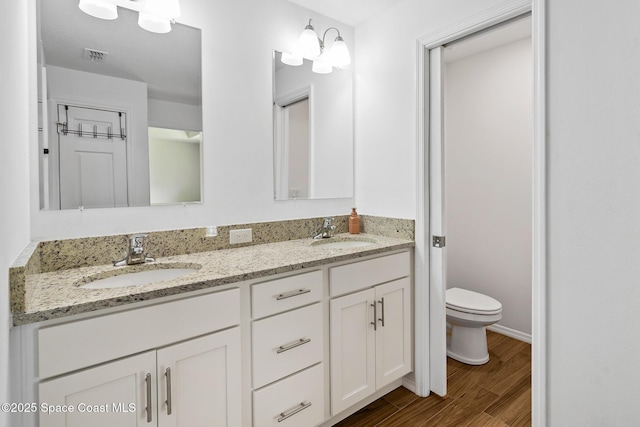 bathroom with hardwood / wood-style floors, vanity, and toilet