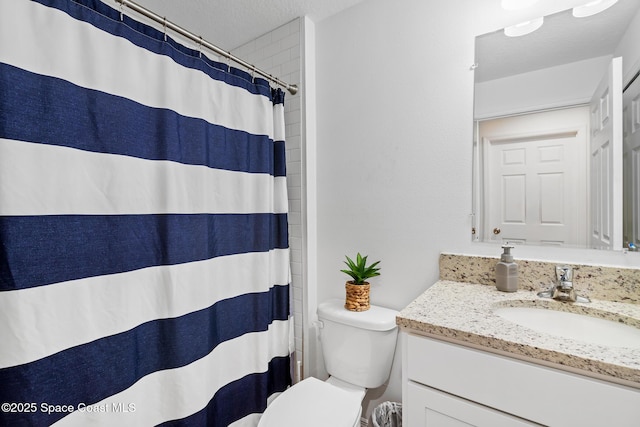 bathroom featuring walk in shower, vanity, a textured ceiling, and toilet