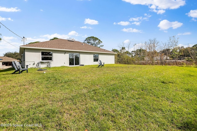 rear view of property featuring a lawn