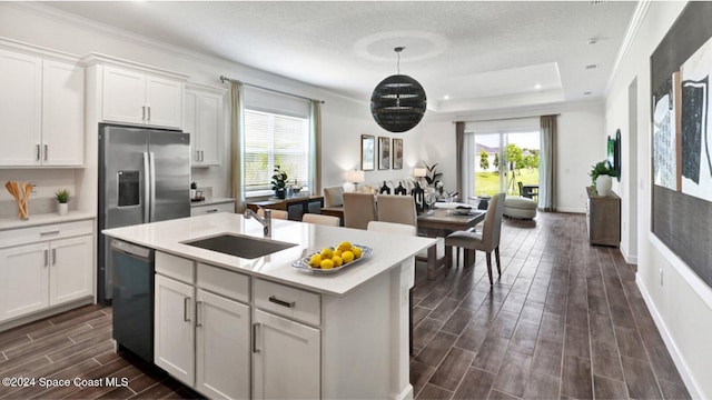 kitchen featuring stainless steel refrigerator with ice dispenser, sink, pendant lighting, dishwasher, and white cabinetry