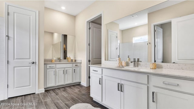 bathroom featuring a shower and vanity