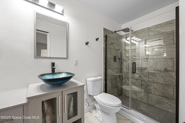 bathroom featuring vanity, a shower with shower door, and toilet