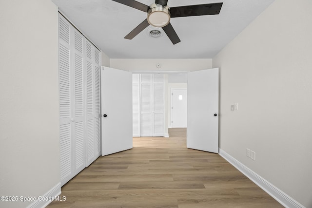 unfurnished bedroom featuring a closet, ceiling fan, and light hardwood / wood-style flooring