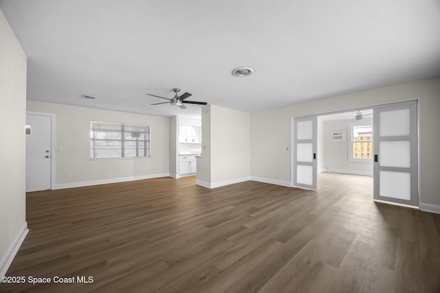 unfurnished living room with ceiling fan and dark hardwood / wood-style flooring