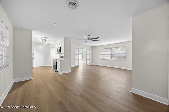 unfurnished living room with hardwood / wood-style flooring and ceiling fan