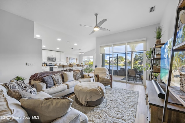 living room featuring light wood-type flooring, vaulted ceiling, and ceiling fan