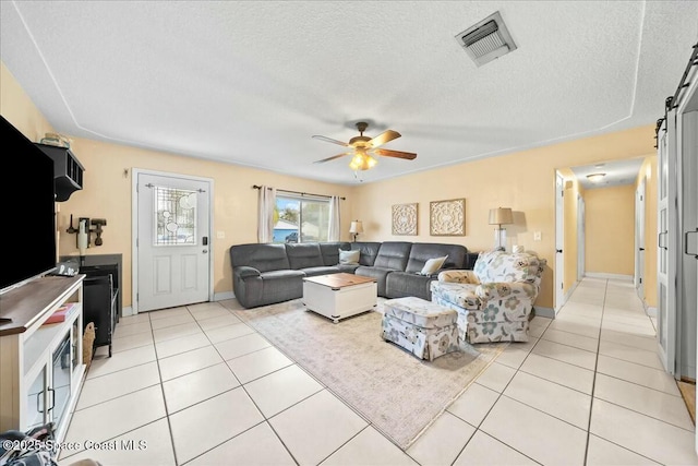 tiled living room with ceiling fan and a textured ceiling