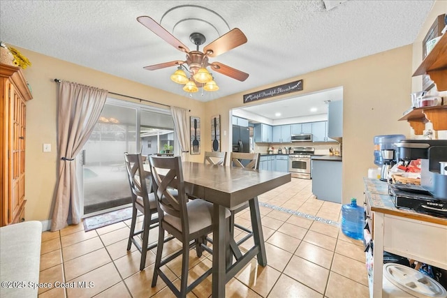 tiled dining room featuring ceiling fan and a textured ceiling