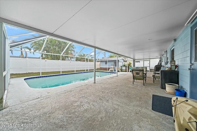 view of swimming pool with glass enclosure and a patio area