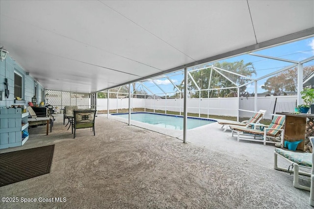 view of swimming pool featuring a patio area and glass enclosure