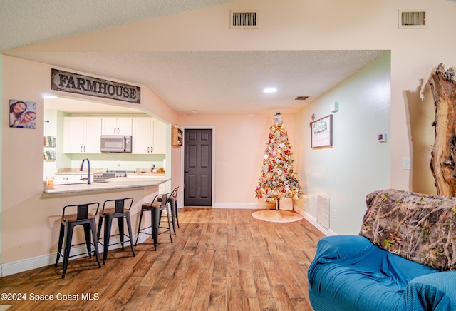 interior space with a textured ceiling, light wood-style flooring, visible vents, and baseboards