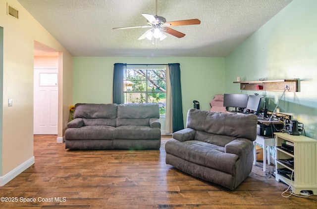 living area with lofted ceiling, visible vents, a ceiling fan, a textured ceiling, and wood finished floors