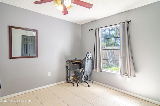 tiled office space featuring a textured ceiling, baseboards, and a wealth of natural light