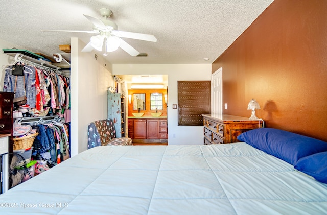 bedroom featuring a closet, visible vents, ceiling fan, and a textured ceiling