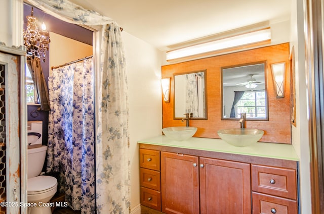 full bath featuring double vanity, toilet, backsplash, and a sink