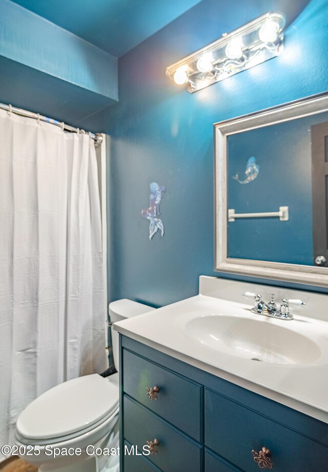 full bathroom with curtained shower, vanity, and toilet