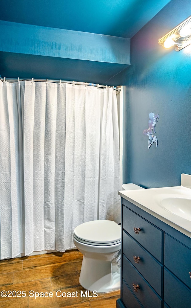 full bathroom with vanity, toilet, and wood finished floors