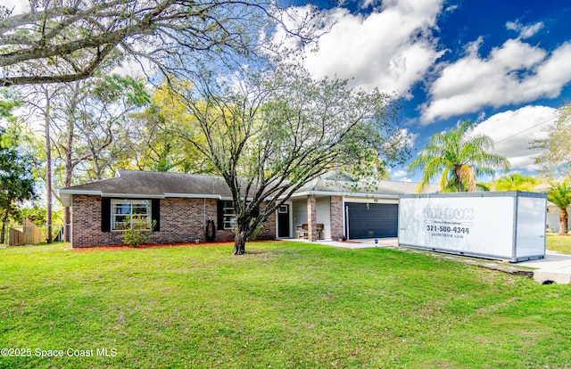 ranch-style home featuring a garage, a front yard, brick siding, and driveway