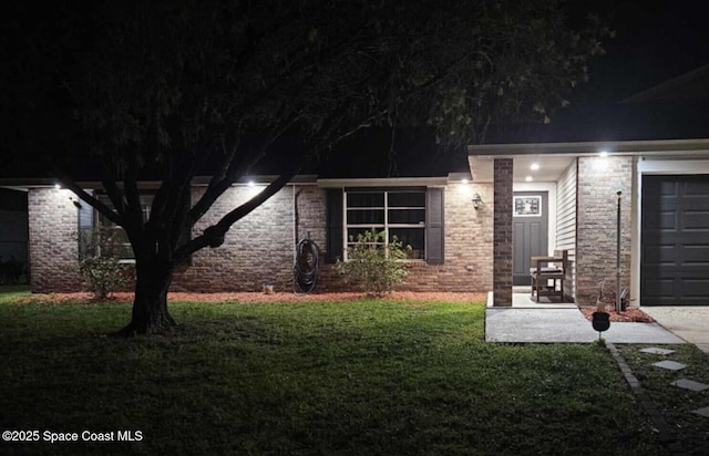 rear view of property with a lawn and brick siding