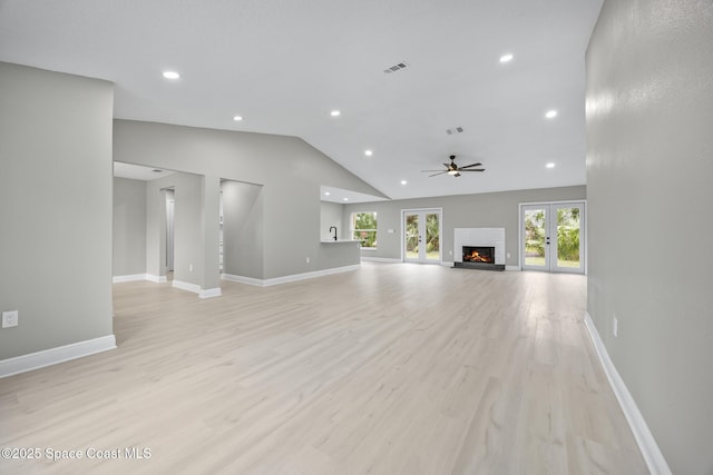 unfurnished living room with ceiling fan, lofted ceiling, french doors, and light hardwood / wood-style flooring