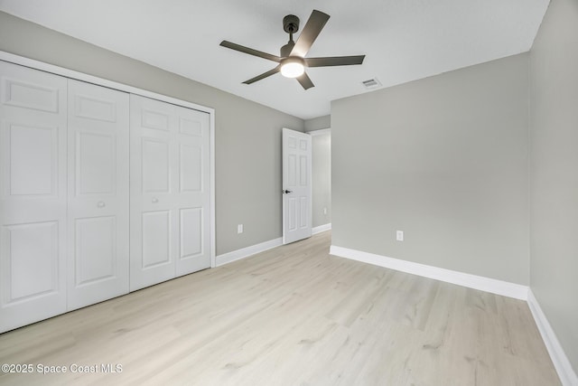 unfurnished bedroom featuring ceiling fan, a closet, and light hardwood / wood-style flooring