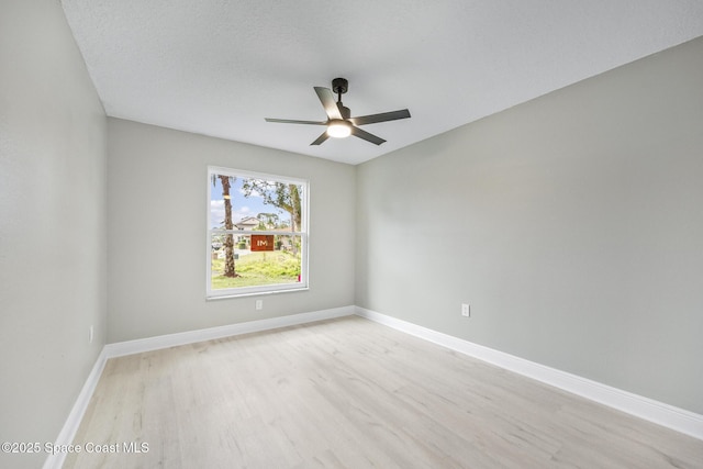 empty room with ceiling fan and light hardwood / wood-style floors