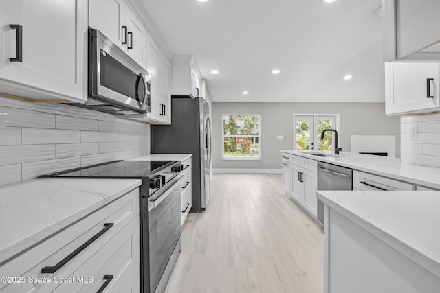 kitchen with tasteful backsplash, white cabinetry, and stainless steel appliances