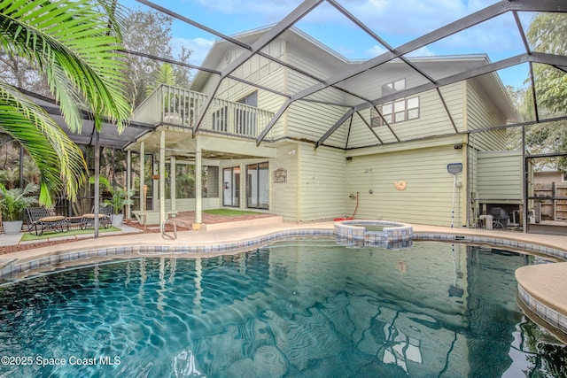 view of swimming pool with an in ground hot tub, cooling unit, glass enclosure, and a patio