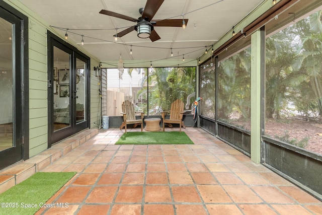 unfurnished sunroom featuring ceiling fan