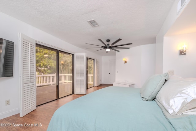 bedroom with a textured ceiling, light hardwood / wood-style flooring, ceiling fan, and access to outside