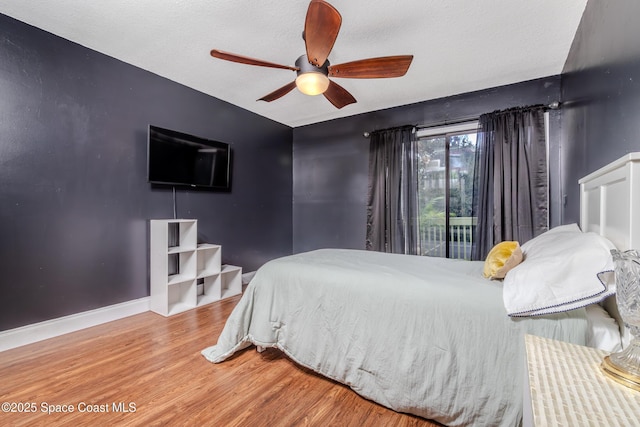 bedroom featuring ceiling fan, access to outside, a textured ceiling, and hardwood / wood-style flooring