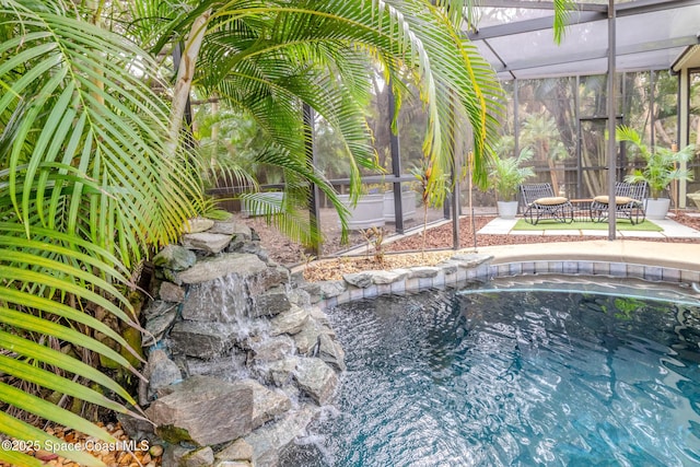 view of swimming pool featuring a lanai