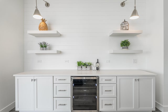 bar featuring white cabinetry, beverage cooler, and decorative light fixtures