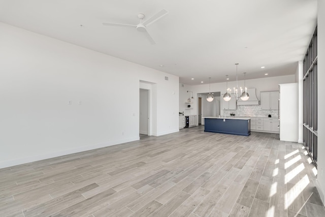 unfurnished living room with ceiling fan and light wood-type flooring