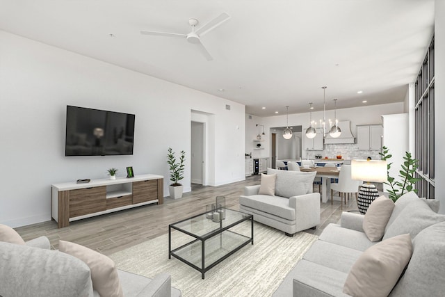 living room with light wood-type flooring and ceiling fan